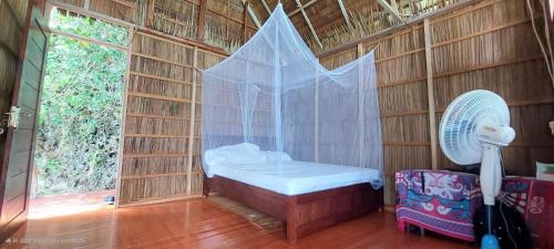 a small room with a bed and a fan at Mamere Homestay Raja Ampat in Fam