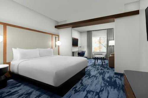 a hotel room with a white bed and a desk at Fairfield Inn & Suites Riverside Corona/Norco in Norco