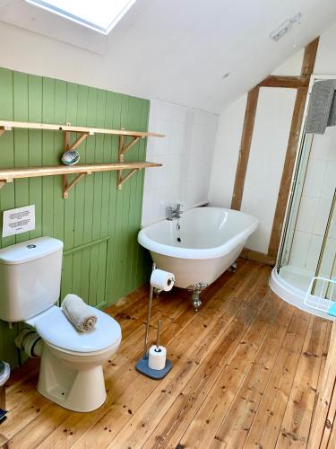 a bathroom with a tub and a toilet and a sink at The Cottage @ Mill Haven place in Pembrokeshire