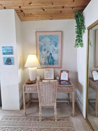 a desk with a lamp and a chair in a room at Belle Vue Waimea - Big Island of Hawaii in Puopelu