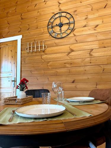 a wooden table with a clock on the wall at Kota coeur de bois in Bourbourg