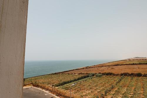 a view of a field of crops with the ocean at Le Bohemian 2 chambres proche Plage des Nations avec Vue sur mer in Sidi Bouqnadel