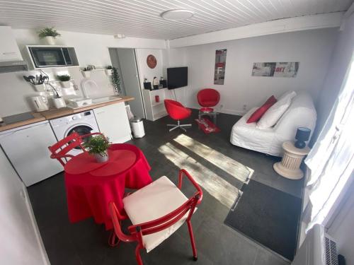 a small living room with a red table and a kitchen at Coca-Cola Studio near Paris in Saint-Denis