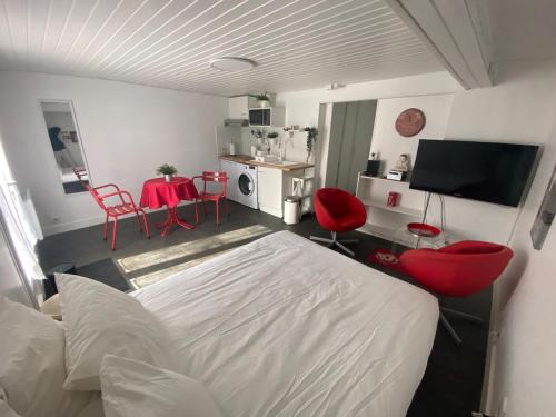 a bedroom with a bed and red chairs and a table at Coca-Cola Studio near Paris in Saint-Denis
