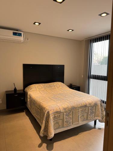 a bedroom with a bed and a large window at Depto Nuevo Belgrano in Villa Mercedes