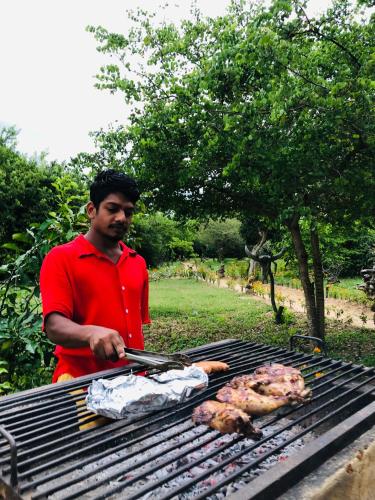 a man is cooking chickens on a grill at Eagle Eye Yala in Yala