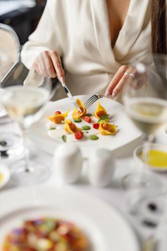 a person eating a plate of food on a table at Baglioni Hotel Regina - The Leading Hotels of the World in Rome