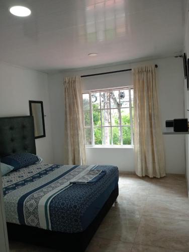 a bedroom with a bed and a large window at Apartamento Fontana 2 in Bucaramanga