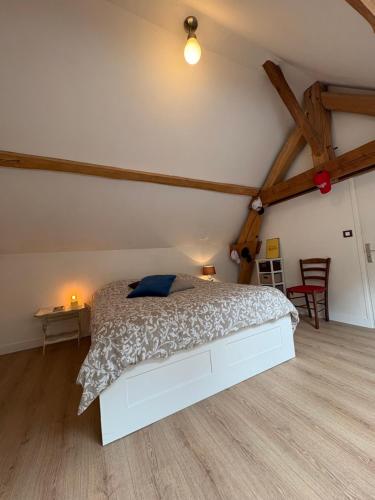 ein Schlafzimmer mit einem weißen Bett auf einem Dachboden in der Unterkunft Maison de charme en bord de Loire in Montlouis-sur-Loire