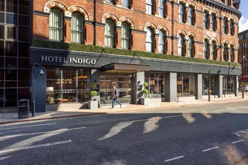 a person walking in front of a hotel indoco building at Hotel Indigo Leeds by IHG in Leeds