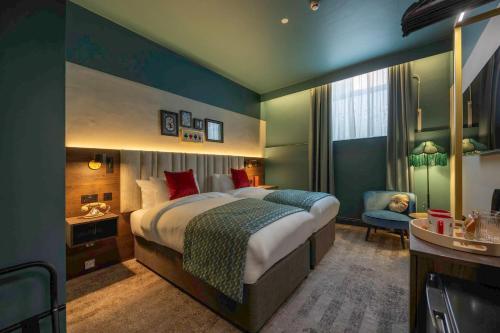 a hotel room with a large bed and a chair at Hotel Indigo Leeds by IHG in Leeds