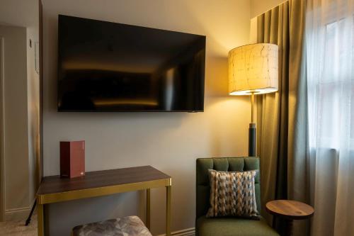 a hotel room with a chair and a television on the wall at Hotel Indigo Leeds by IHG in Leeds