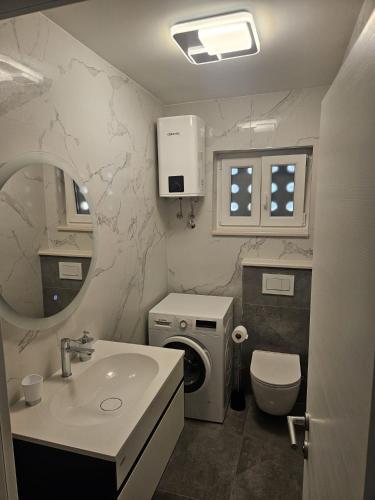 a bathroom with a sink and a toilet and a mirror at Apartments with parking space Omis - 14422 in Omiš