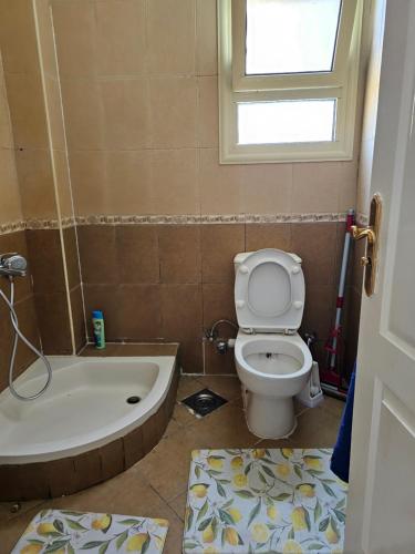 a bathroom with a toilet and a bath tub at Pool & Beach Apartment in Sharm El Sheikh