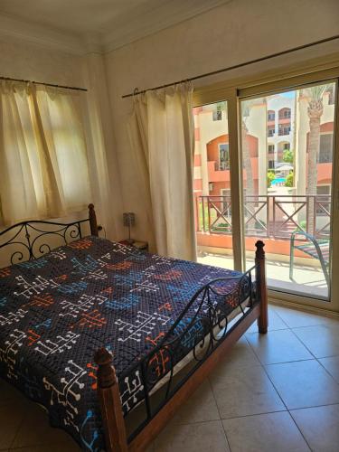 a bedroom with a bed and a large window at Pool & Beach Apartment in Sharm El Sheikh