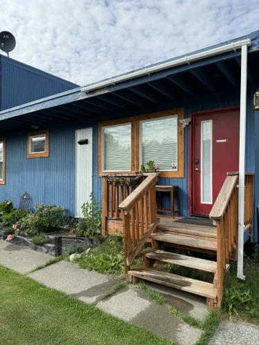 a house with a red door and a wooden porch at Nightshade BnB in Anchorage
