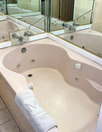 a bath tub with a towel on the side of it at The Maddox Inn in Chincoteague