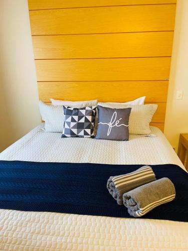 a bed with a wooden headboard and pillows on it at Flat de Luxo Aeroporto Congonhas - Hotel in São Paulo