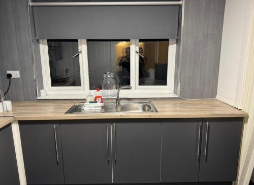 a kitchen counter with a sink and a mirror at 118 NELSON STREET 1st FLOOR , LARGS in Largs