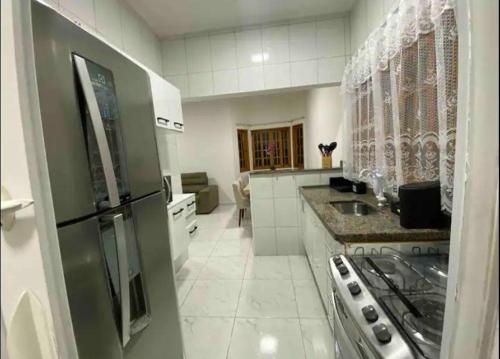 アチバイアにあるLinda casa em condominioのキッチン(冷蔵庫、コンロ付)