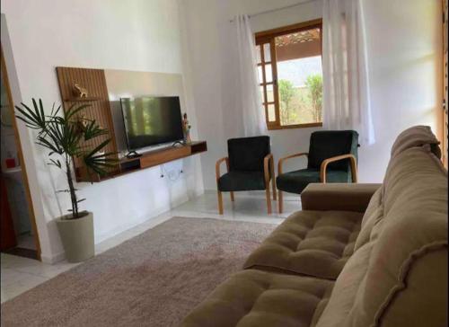 アチバイアにあるLinda casa em condominioのソファと椅子2脚のあるリビングルーム