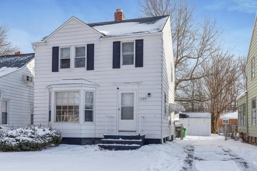 a white house with a white door in the snow at Entire 3 bed home in South Euclid w ac in South Euclid