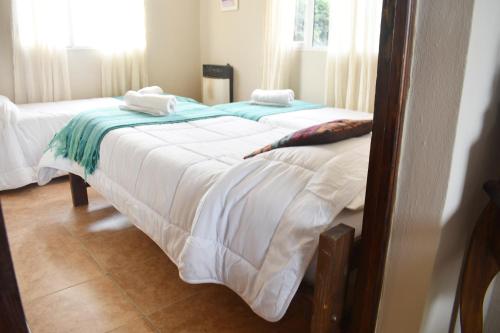 two beds with towels on top of them in a room at Hotel Cabañas Aparts Tierra de Glaciares in El Calafate