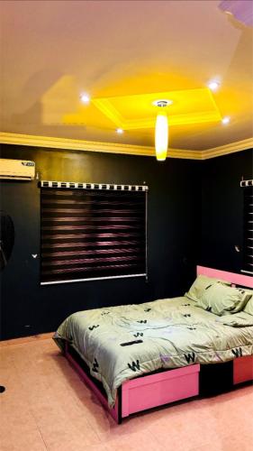 a bedroom with a bed with a yellow ceiling at Beautiful 5 bedroom Bungalow in Ibadan