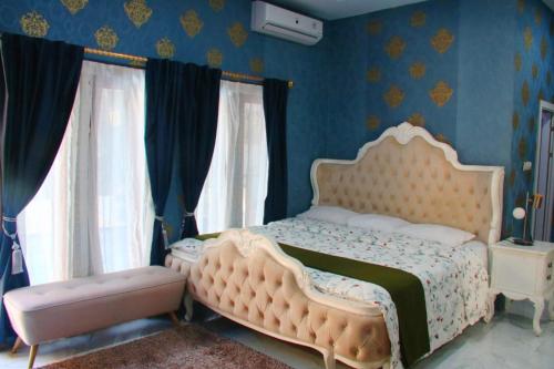 a bedroom with a white bed and blue walls at Adiwinoto villa and Homestay in Banyuwangi