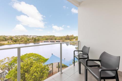 a balcony with two chairs and a view of the water at Best Western Plus North Lakes Hotel in North Lakes
