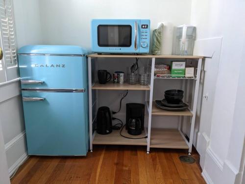 a blue refrigerator and a microwave on a shelf at Efficiency In Grand Old Home, Downtown Durham in Durham
