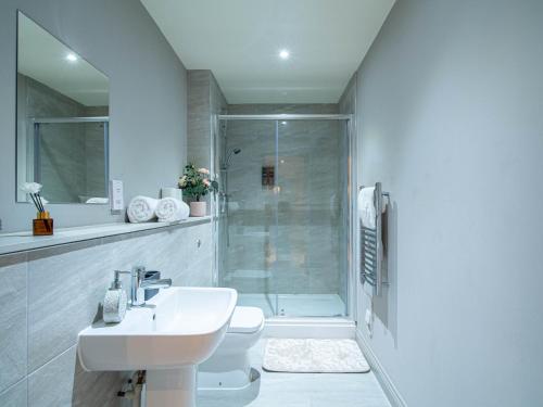 a white bathroom with a shower and a sink at Central Leeds Apartment near Arena and Victoria Quarter in Leeds