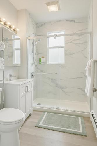 a white bathroom with a shower and a toilet at Beautiful Chicago 2BD 1BA in Chicago