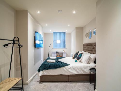a bedroom with a large bed with blue windows at Central Leeds Apartment near Arena and Victoria Quarter in Leeds