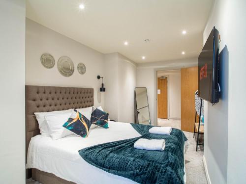 a bedroom with a large bed and a flat screen tv at Central Leeds Apartment near Arena and Victoria Quarter in Leeds