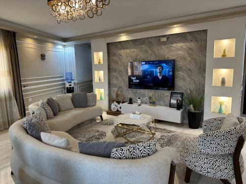 a living room with a couch and a tv on a wall at Luxurious apartment in cairo in Cairo