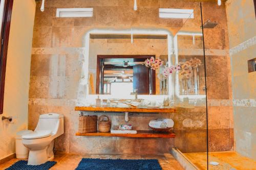 a bathroom with a toilet and a glass shower at Muúnek Hotel Boutique Art & Spa, adults only in Barra Vieja