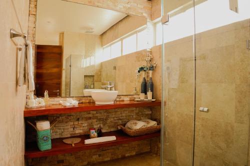 a bathroom with a glass shower and a sink at Muúnek Hotel Boutique Art & Spa, adults only in Barra Vieja