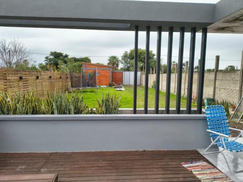 a blue chair sitting on a porch looking out at a yard at Cabaña La Luisa DOS pileta quincho salon in Formosa