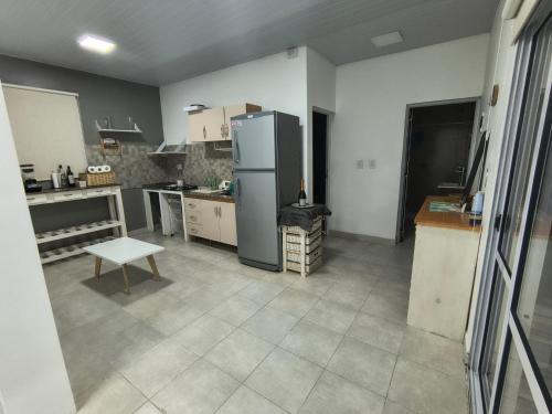 a kitchen with a refrigerator and a table in it at Cabaña La Luisa DOS pileta quincho salon in Formosa
