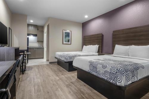 a hotel room with two beds and a kitchen at SureStay Plus Hotel by Best Western Ada in Ada