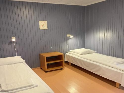 une chambre avec deux lits et une table de chevet avec un lit carré dans l'établissement 7 person holiday park home in Lærdal, à Lærdalsøyri