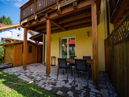 a patio with a table and chairs under a wooden pergola at Villa with terrace, sauna near the border triangle in Arnoldstein