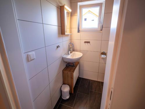 a small bathroom with a sink and a window at Villa with terrace, sauna near the border triangle in Arnoldstein