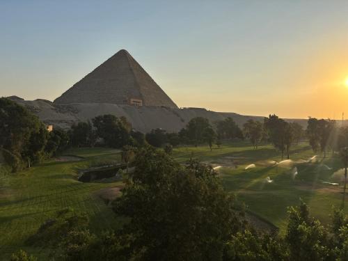 an image of the pyramids of giza at sunset at Beit Khufu Pyramid Hotel in Cairo