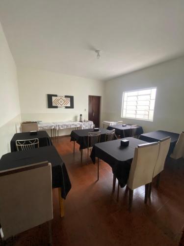 a dining room with tables and chairs and a window at Hotel Rezende in Villa Nova de Resende
