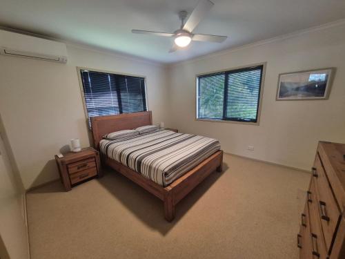 a bedroom with a bed and a ceiling fan at Seas The Day - Free Wifi, 180m Walk TO THE Beach in Vincentia