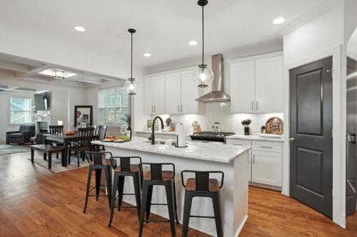 een keuken met witte kasten en een eiland met barkrukken bij Downtown Oasis Sleeps 12 and 1 and a half miles to Broadway in Nashville