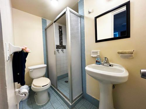 Un baño con inodoro, lavabo y ducha. en Beachfront Condo Enjoy Paradise!, en Playas de Rosarito