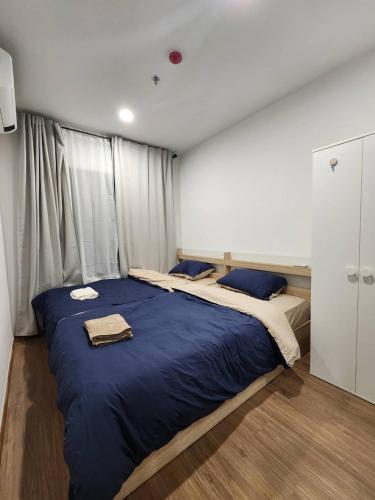 a bedroom with a large bed with blue sheets at Cozy Downtown Apartment - long stay in Bangkok- MRT Phasi charoen in Bangkok